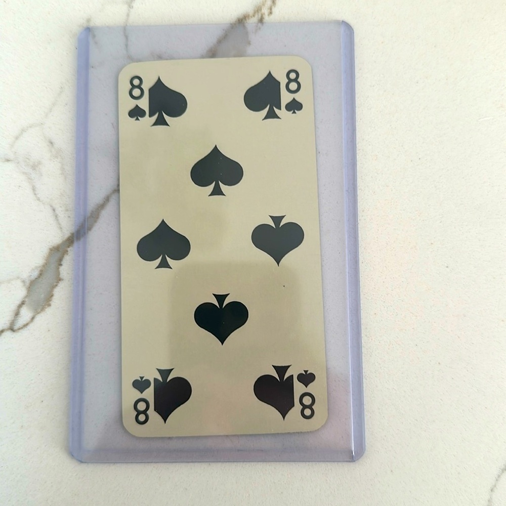 Hermes playing card 8 of Spades in a protective case